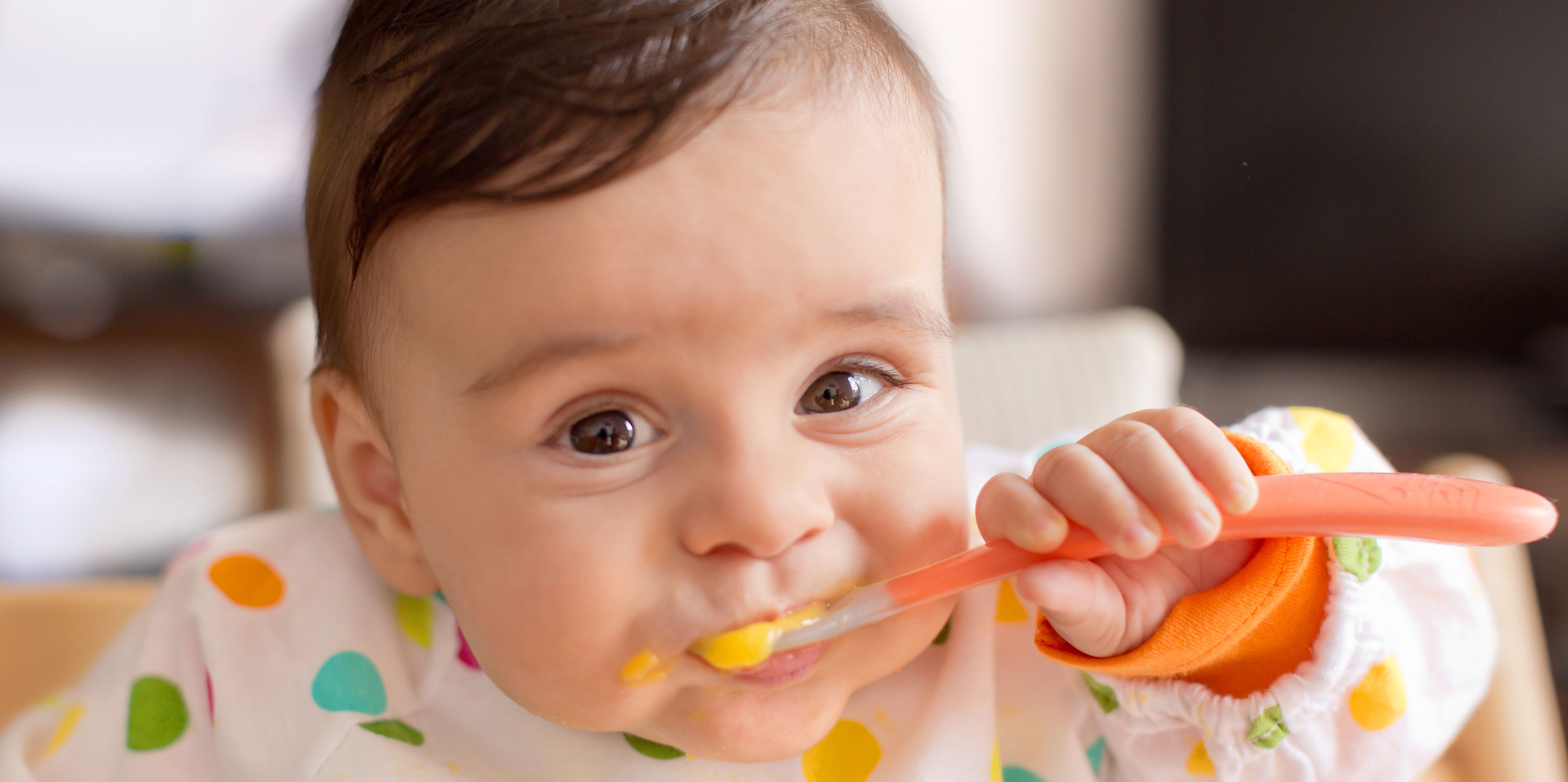 Bebé comiendo con cuchara en la boca