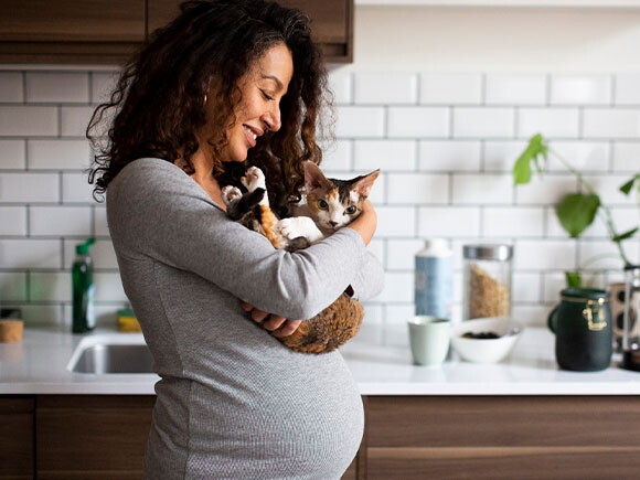 Mujer embarazada sosteniendo su gatito