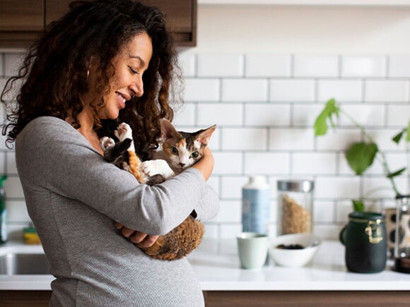 Mujer embarazada sosteniendo su gatito