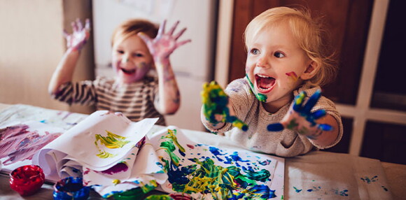Niños pintando con pintura y riendo